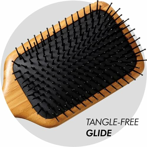 Bamboo hairbrush with black bristles labeled tangle-free glide.