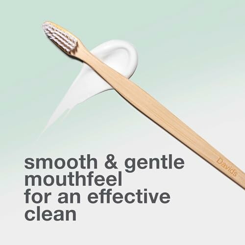 Bamboo toothbrush with toothpaste swirl and text: smooth & gentle mouthfeel for an effective clean