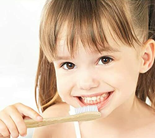 Child brushing teeth with a bamboo toothbrush.