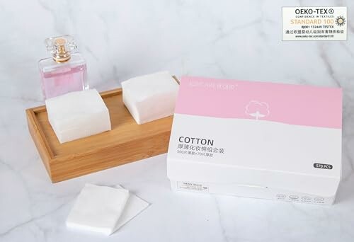 Cotton pads and a perfume bottle on a tray with OEKO-TEX certification.