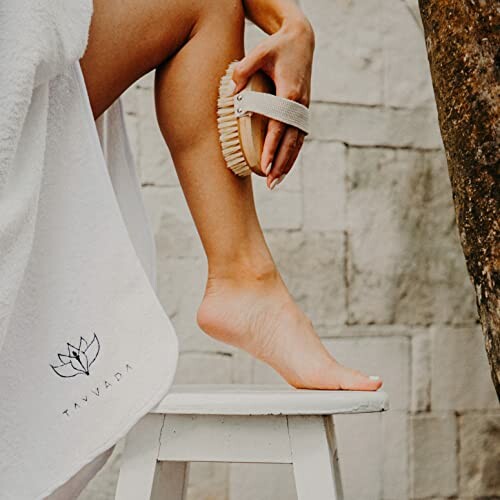 Person dry brushing leg with a brush