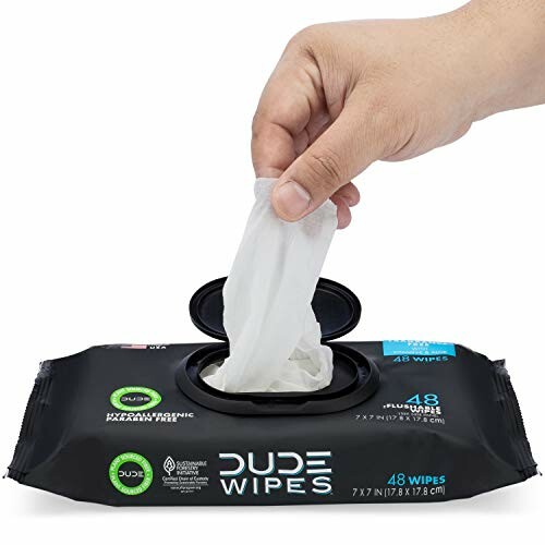 Hand pulling wipe from Dude Wipes package