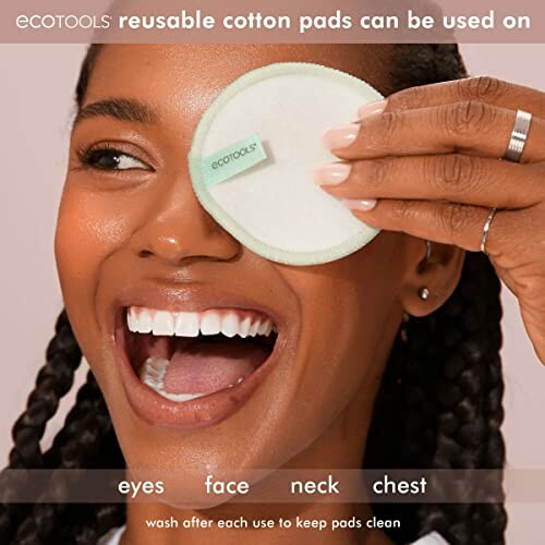 Smiling person using Ecotools reusable cotton pad on face.