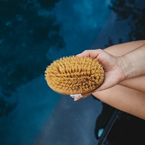 Person holding a dry brush near water