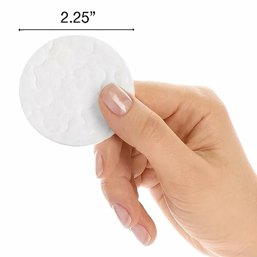 Hand holding a 2.25-inch round cotton pad.