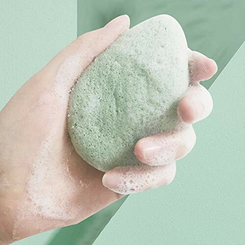 Hand holding a soapy green sponge