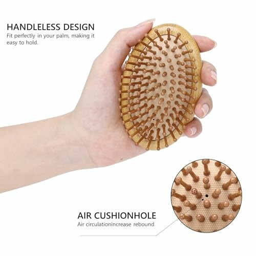 Hand holding an oval hairbrush with air cushion holes.