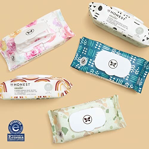 Five packages of Honest baby wipes in different designs on a beige background.