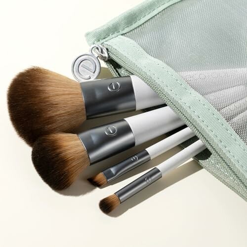 Set of makeup brushes in a green pouch.