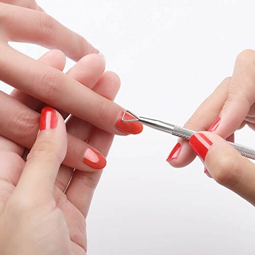 Person receiving a manicure with a cuticle tool