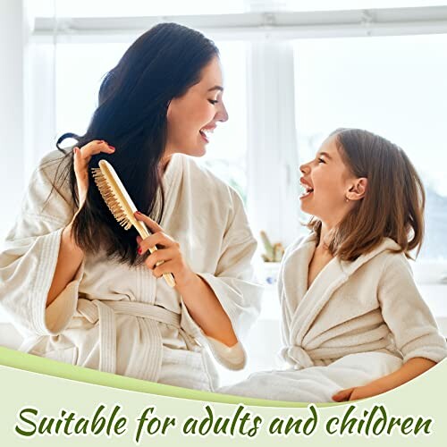 Mother and daughter in robes brushing hair and smiling.