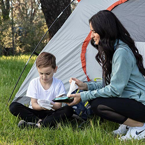 Mother and son sitting by a tent outdoors. Perfect setting for the Surviveware Flushable Wipes for Adults, Men or Women.