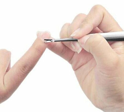 Hands using a tool to remove cuticles from a fingernail, showcasing the effectiveness of the cuticle cleaner.