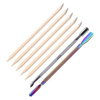 Set of nail care tools including wooden sticks and metal cuticle pushers.