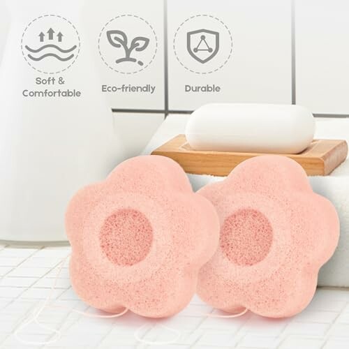 Two pink flower-shaped bath sponges next to a soap bar.