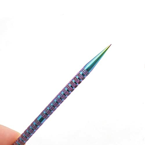 Rainbow-colored pointed metal tool held in hand.