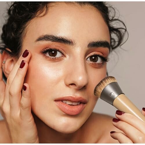 Woman applying makeup with a brush.