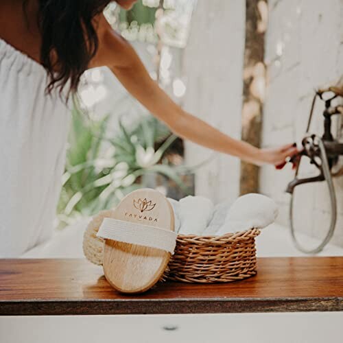 Woman in spa setting with wooden brush and basket on table.