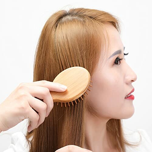 Woman brushing hair with wooden brush.