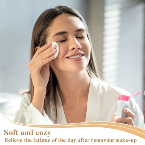 Woman cleansing her face with cotton pad and skincare product.