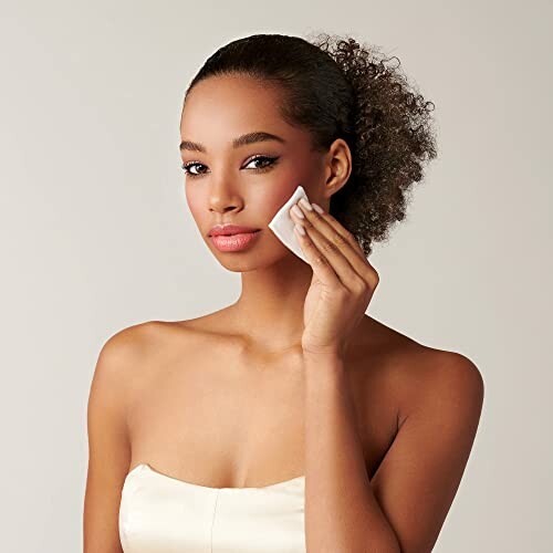 Woman using a cotton pad on her face