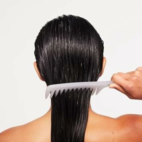 Person combing wet hair from the back