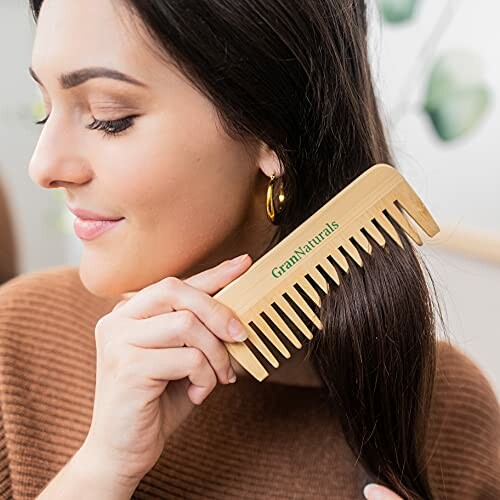 Woman using a wooden comb on her hair