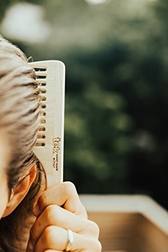 Person using a wooden comb on hair