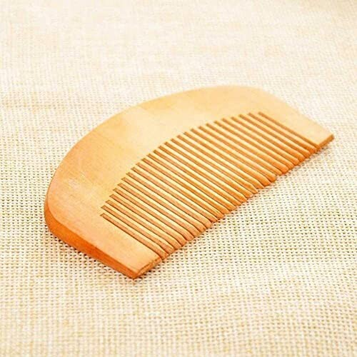 Wooden comb on a beige fabric background