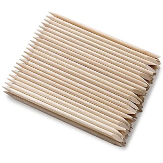 Set of wooden cuticle sticks arranged in a row.