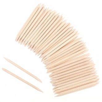 A collection of wooden cuticle sticks arranged in a fan shape.