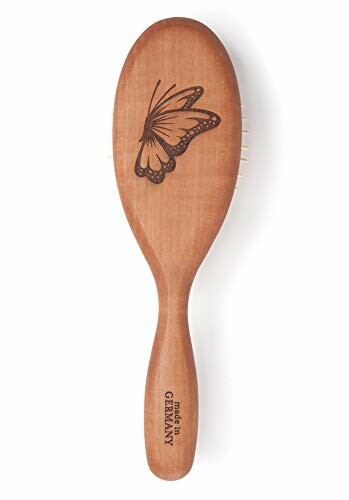 Wooden hairbrush with engraved butterfly design.