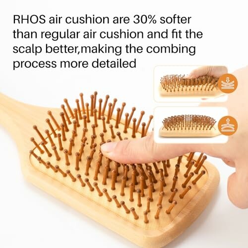 Wooden hairbrush with soft air cushion and finger pressing the bristles.