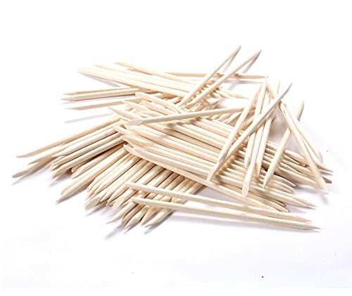 Pile of wooden toothpicks on a white background.