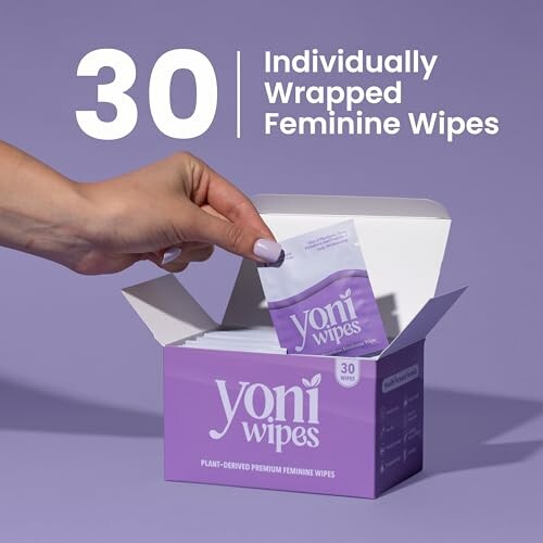 Hand taking a Yoni wipe from a purple box labeled '30 Individually Wrapped Feminine Wipes'.